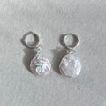 Pair of pearl earrings on a light gray background