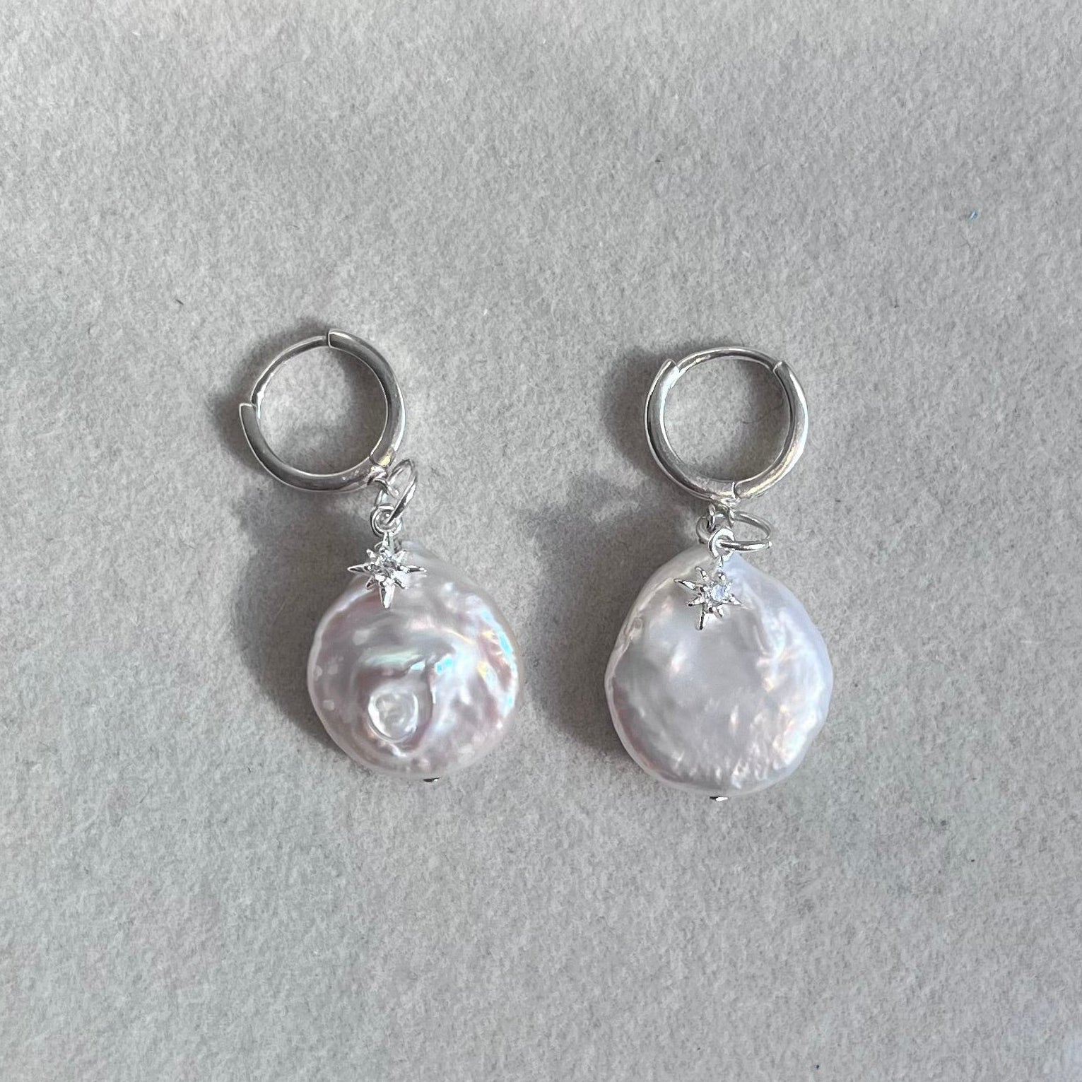 Pair of pearl earrings on a light gray background